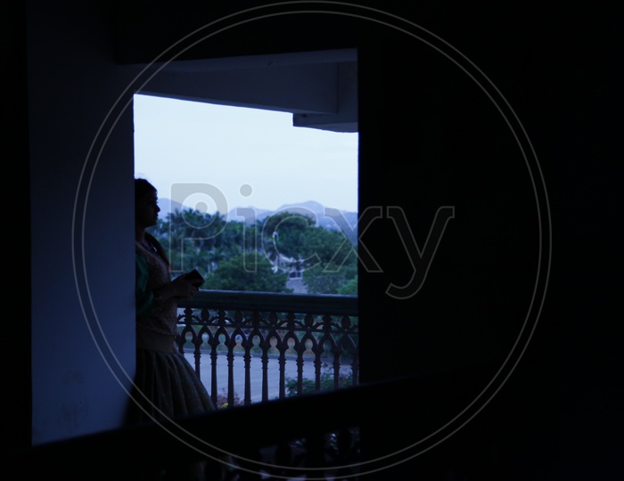 Silhouette Of a Woman Standing at a Window
