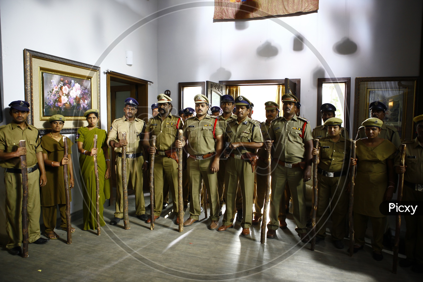 Police Man And Woman Holding Wooden Sticks In Hand in a Police Station