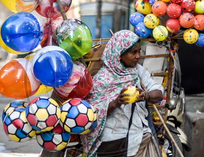 Indian Woman Vendor Selling Colour Balloons On Streets Of Indian City