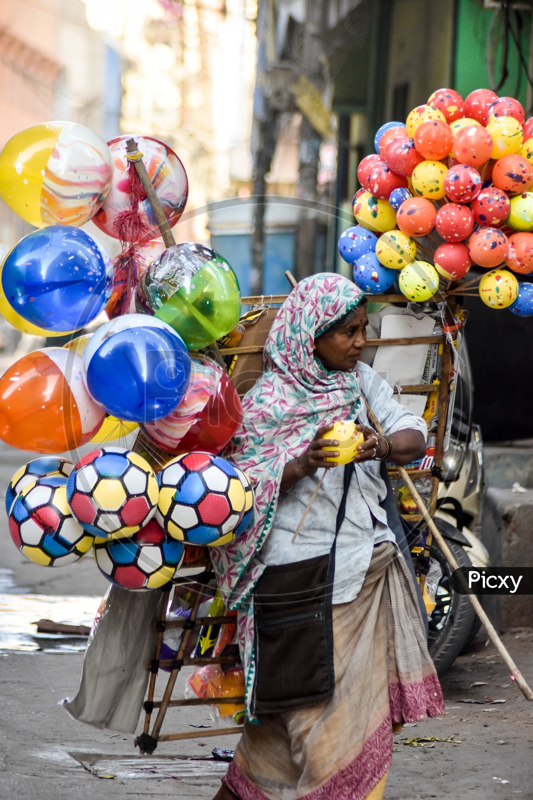Indian Woman Vendor Selling Colour Balloons On Streets Of Indian City