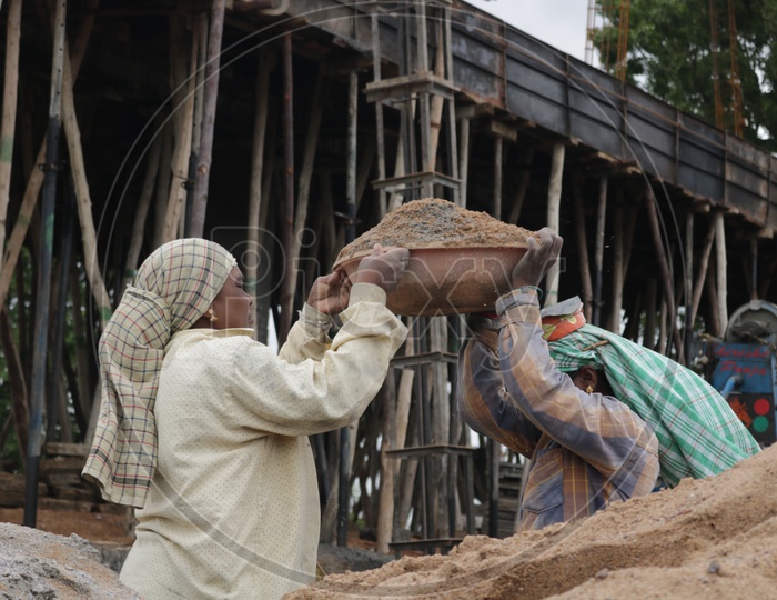 women working at construction site. construction labor lifting sand.