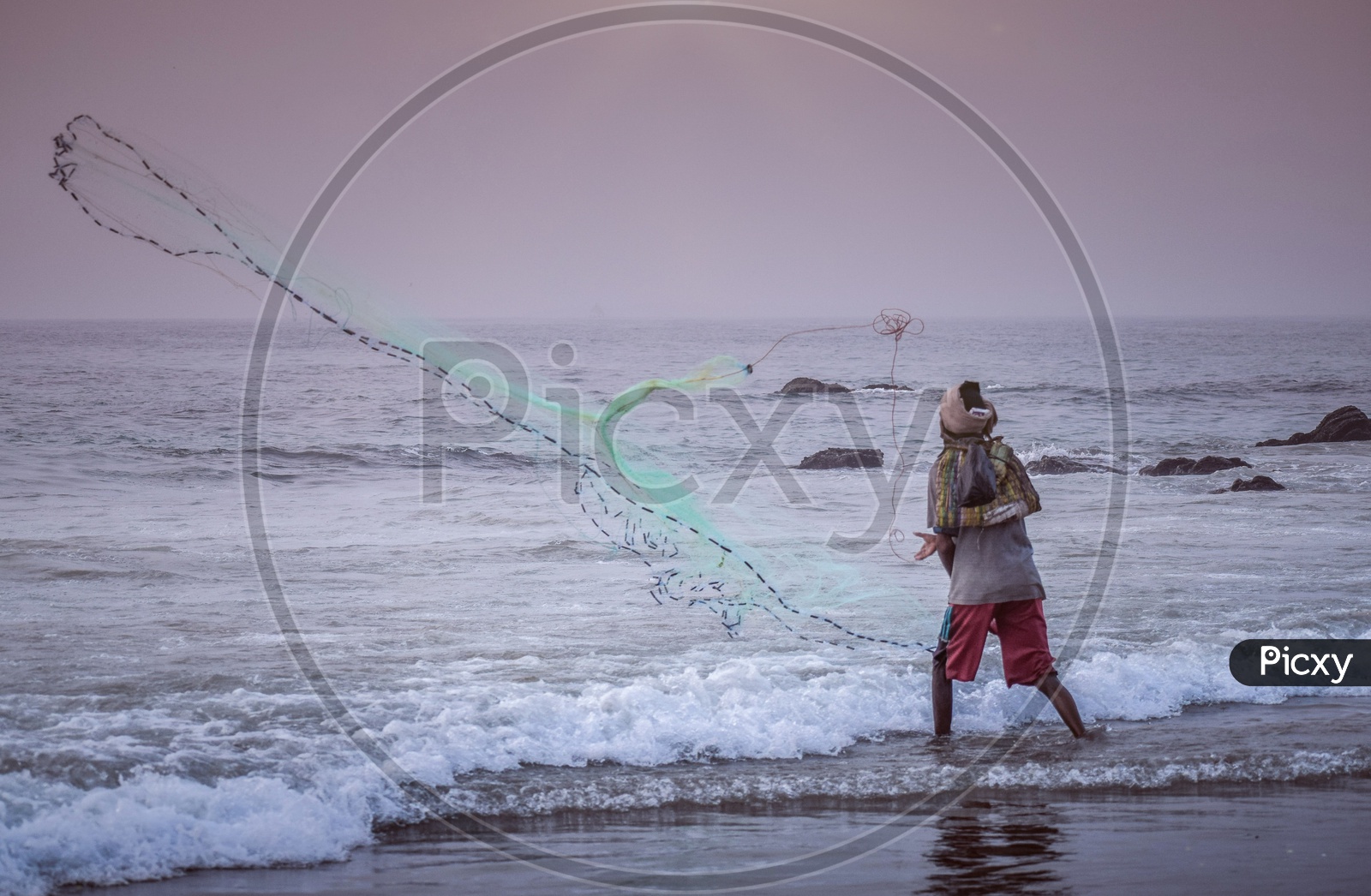 A fisherman throwing Fyke net to catch fishes