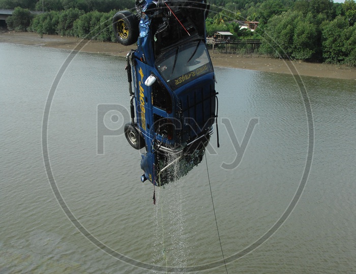 Crane pulling car out of  water