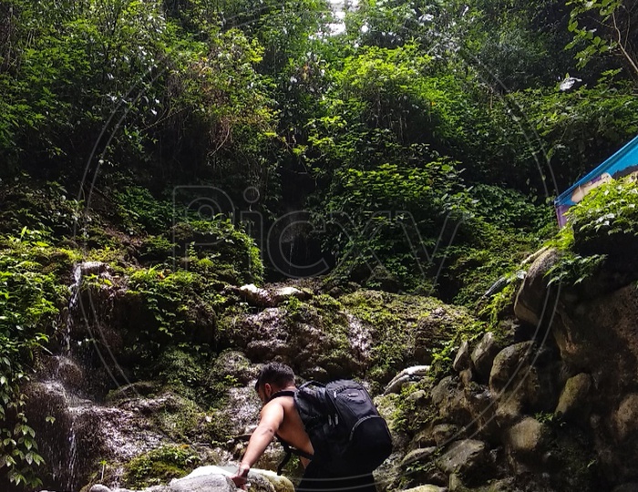 Man climbing to reach waterfall