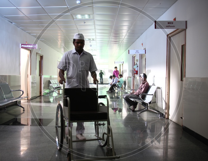 Hospital Corridor With Wheel Chairs And Patients
