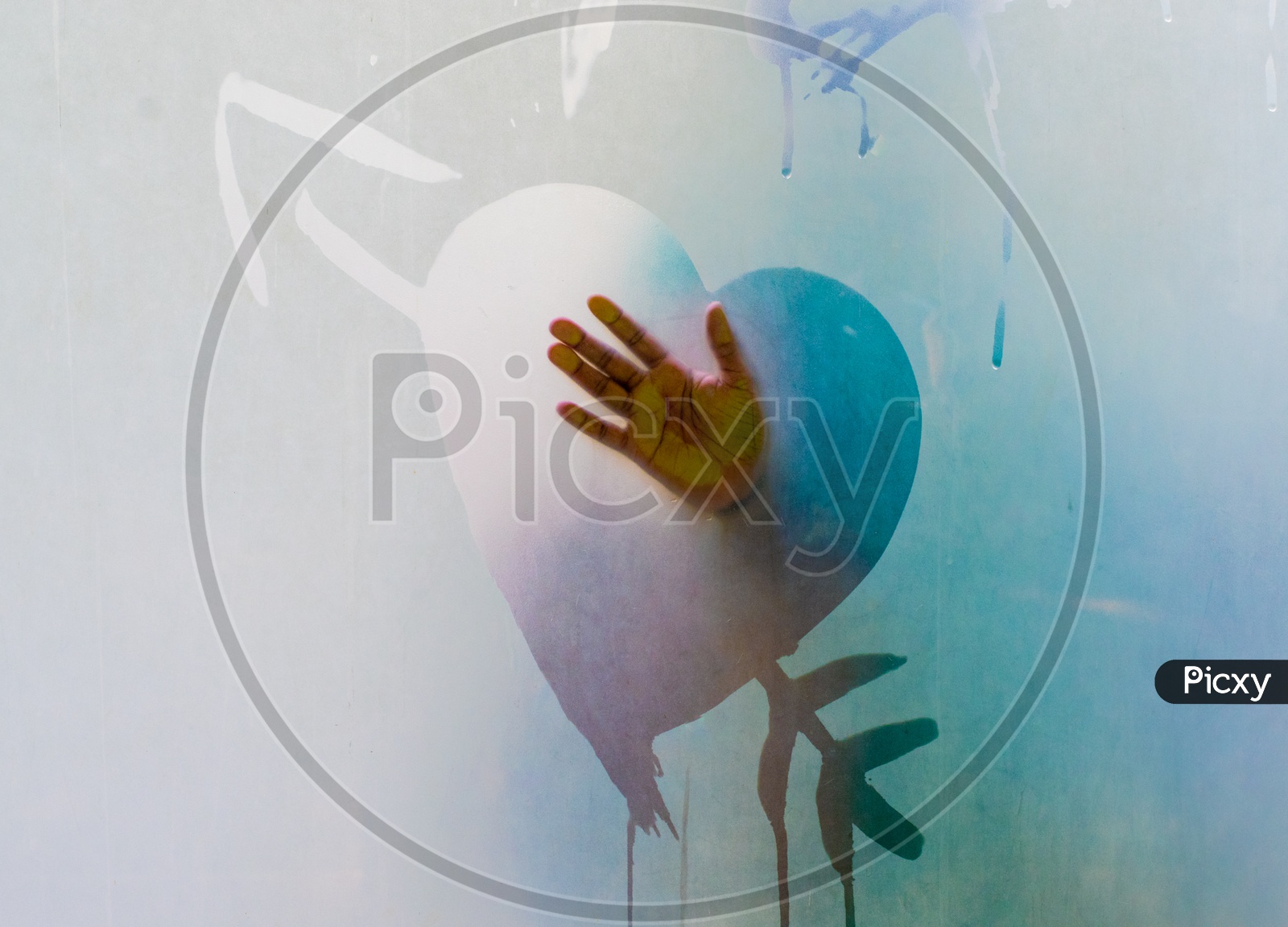 Lady creating a heart symbol on a foggy glass