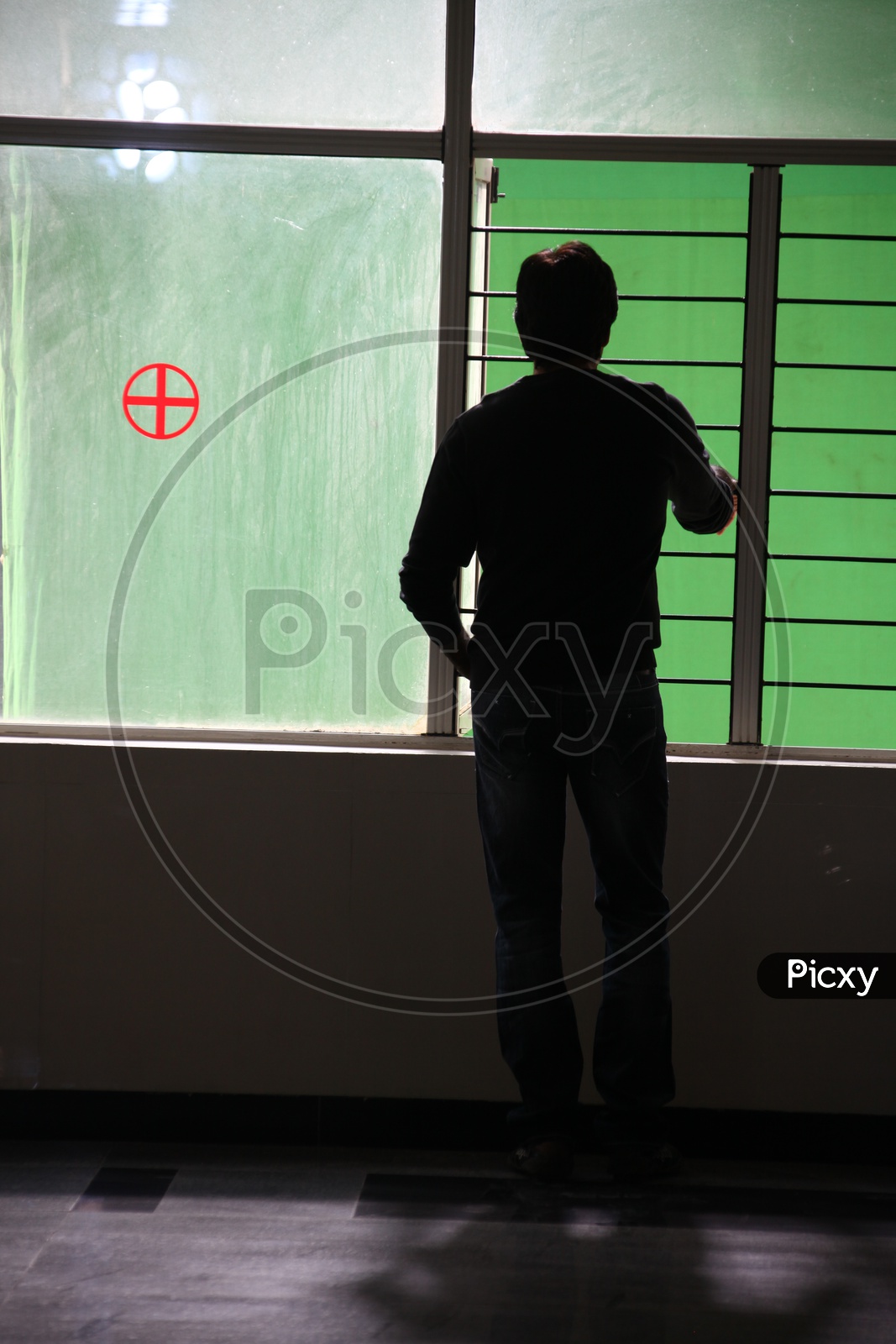 Silhouette Of a Man Standing at a Hospital Window