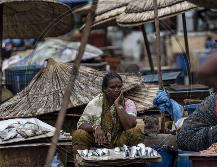 Woman selling fish in rain
