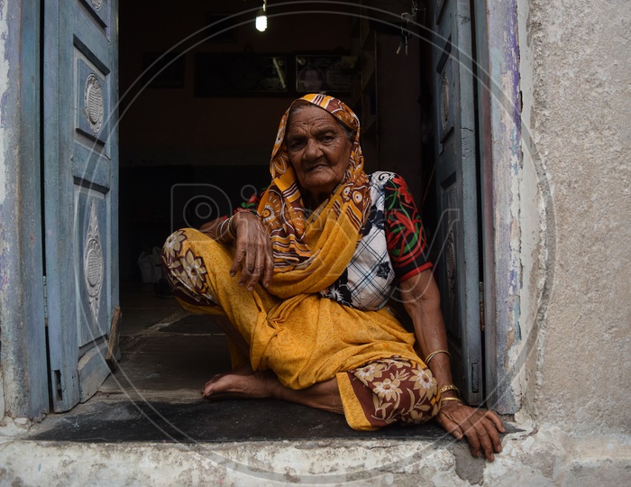 Old lady sitting outside her bangle shop