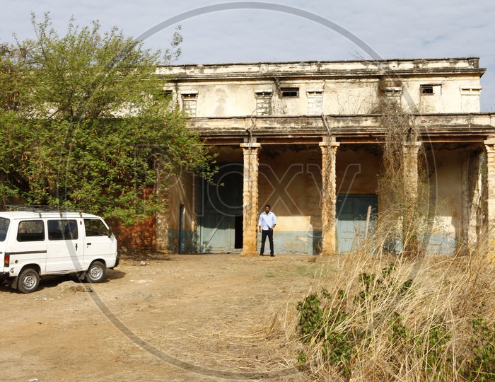 A Man Standing At an Old Deceased Building