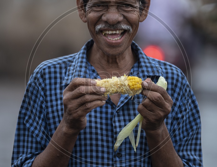 Man eating corn in rain