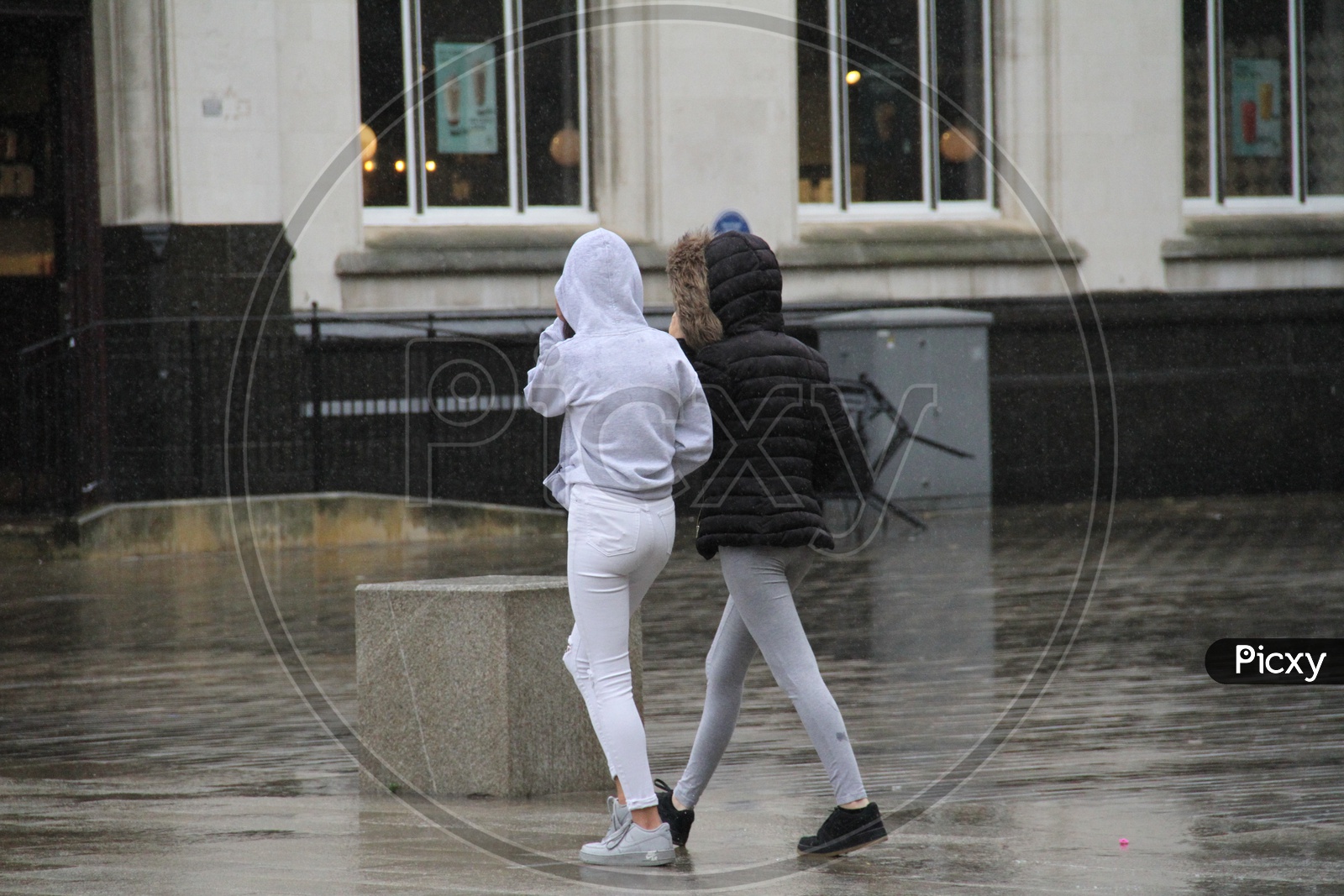 Young Women walking while raining