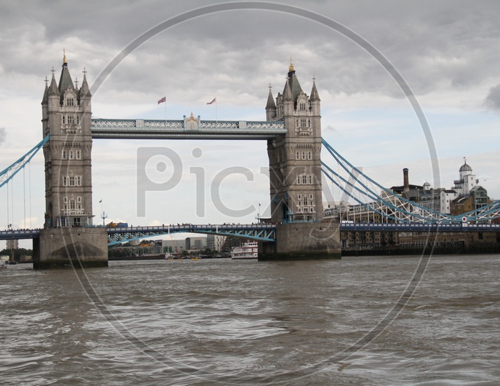 Tower Bridge on Thames River with Dark Clouds in Sky Background