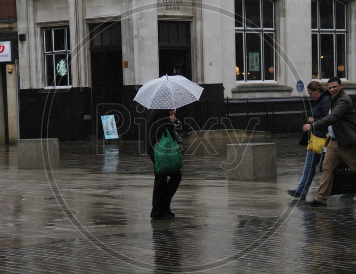 People walking on London Streets while raining