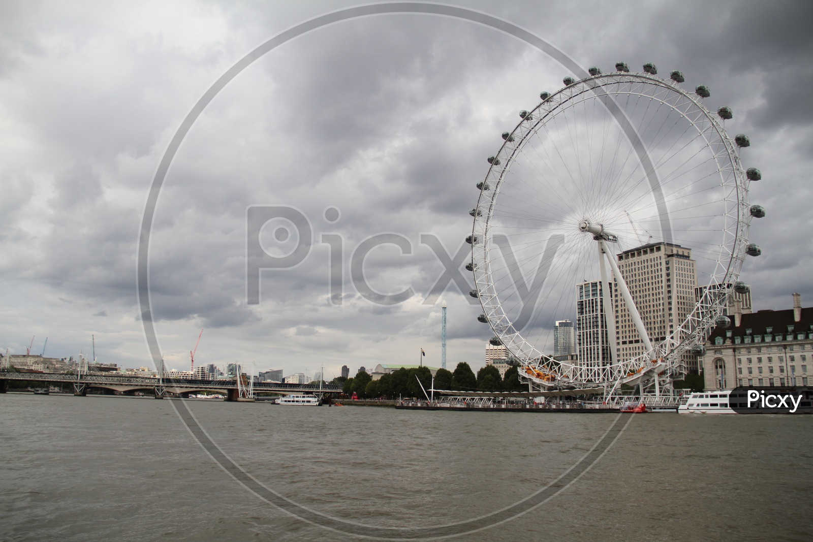 London Eye on Thames River with Dark Clouds in Background