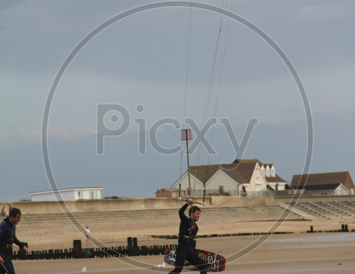 Young Man with Paragliding at Beach