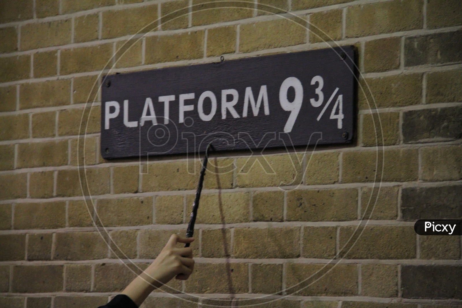 Magic Wand Pointing at Platform 9 3/4 Sign from Harry Potter movie in King's Cross Station