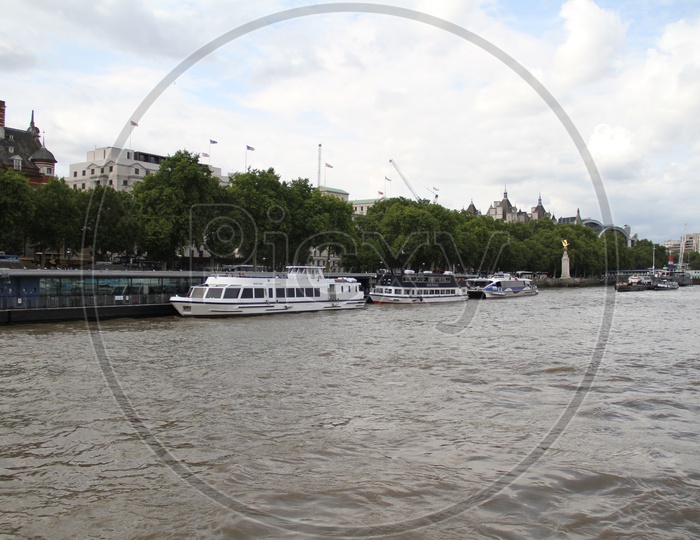 Boats for Tourists on Thames River with Clouds in Background