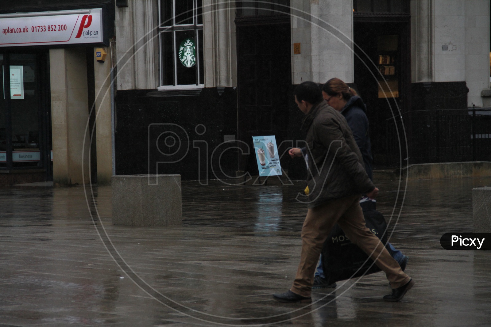 Couple walking on streets while raining