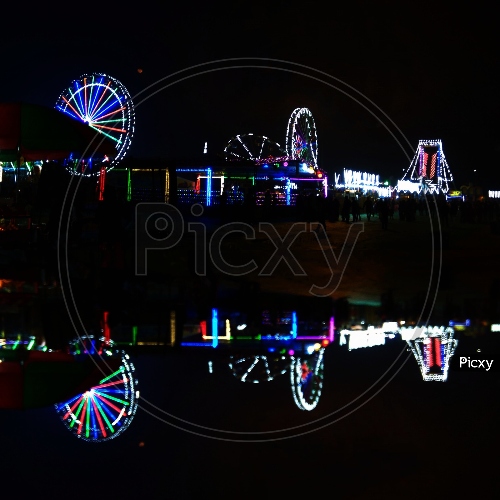 Colorful Lights of giant-wheels and their reflection.