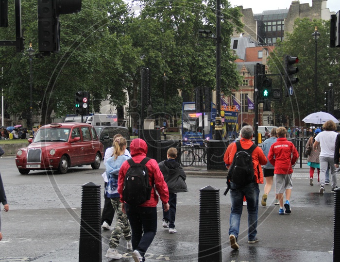 Pedestrians crossing road on Green Signal on rainy Day