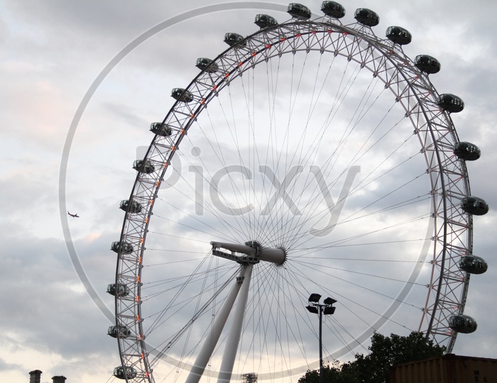 London Eye Ferris Wheel with Flight in Sky Background