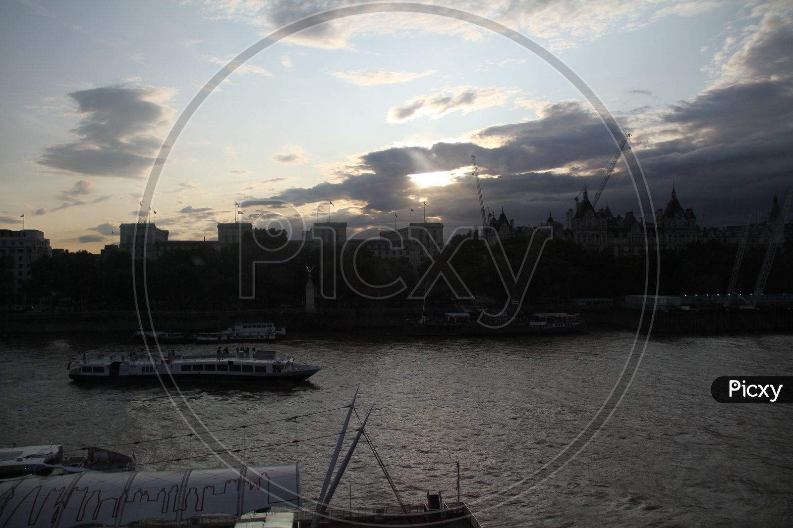 Tourist Boats on Thames River with Clouds in Background