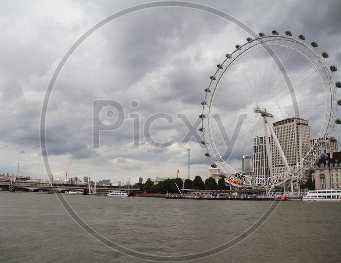 London Eye on Thames River with Dark Clouds in Background