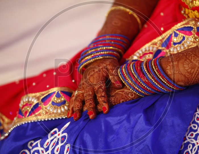 An Indian woman's mehendi hand with matching bangles