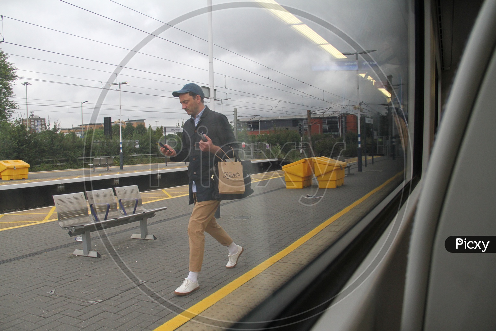 A man walking on Platform with using Mobile or Smartphone