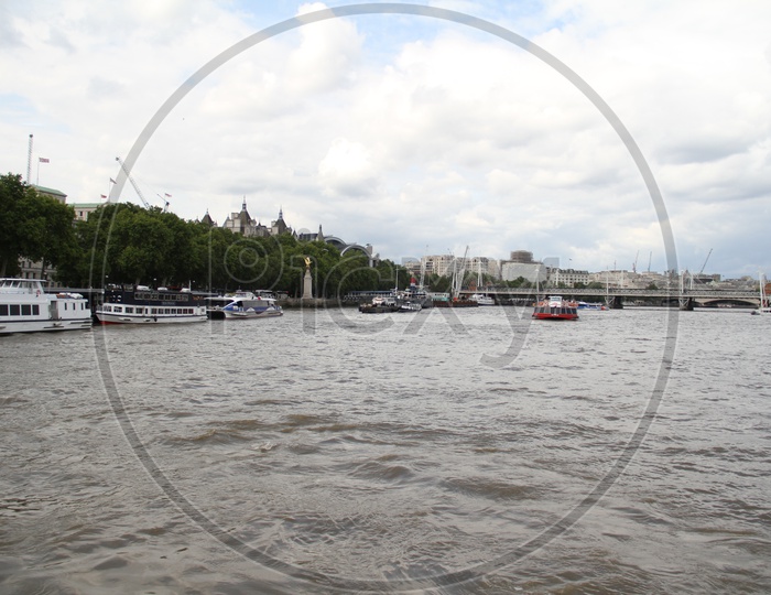 Tourist Boats on Thames River with Clouds in Sky Background