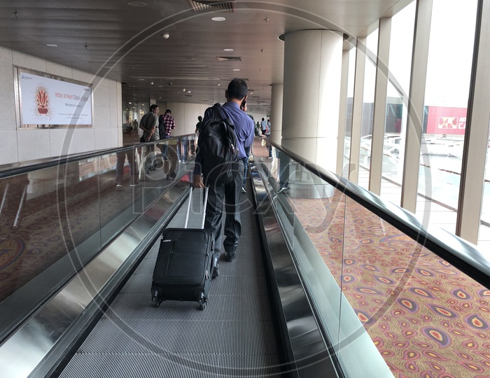 traveler or Passenger Using Flat Escalators With Luggage bags in an Airport