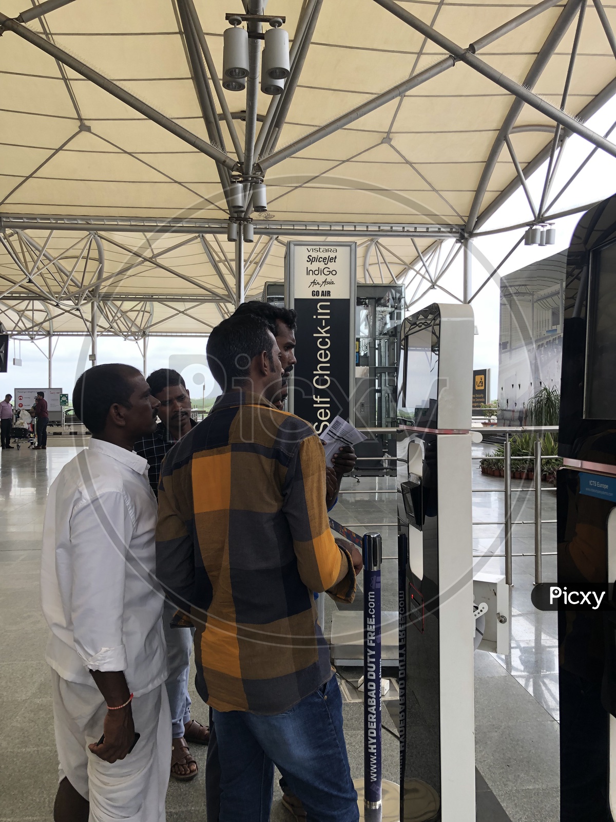 Passengers Using Self Check-in kiosk At Hyderabad Airport