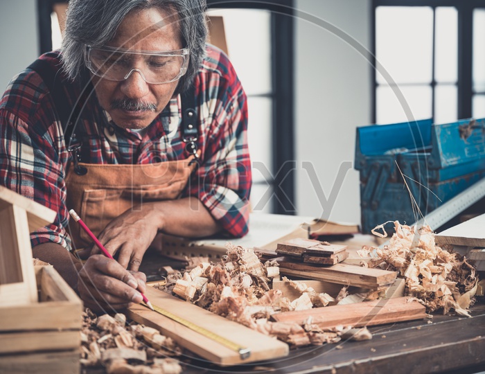 Man doing woodwork in carpentry. Carpenter work on wood plank in workshop
