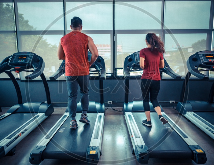 Couple on treadmill exercising in the gym