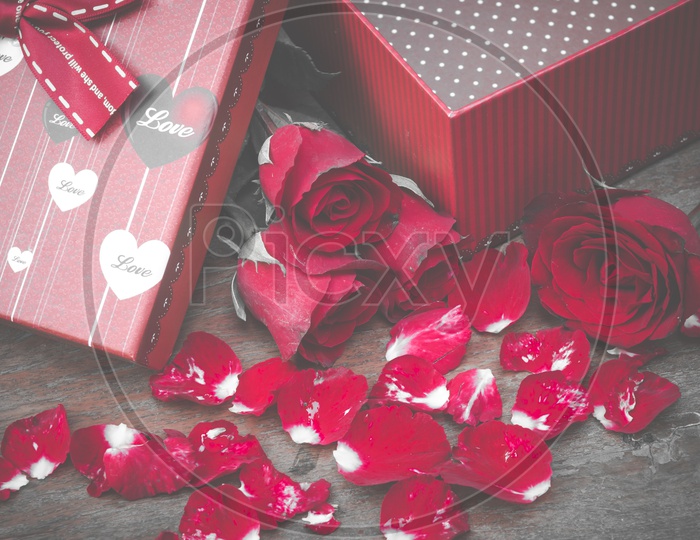 Red Roses And Gift Box Over a Wooden Background Forming Templates For Valentine's Day Or Lovers Day