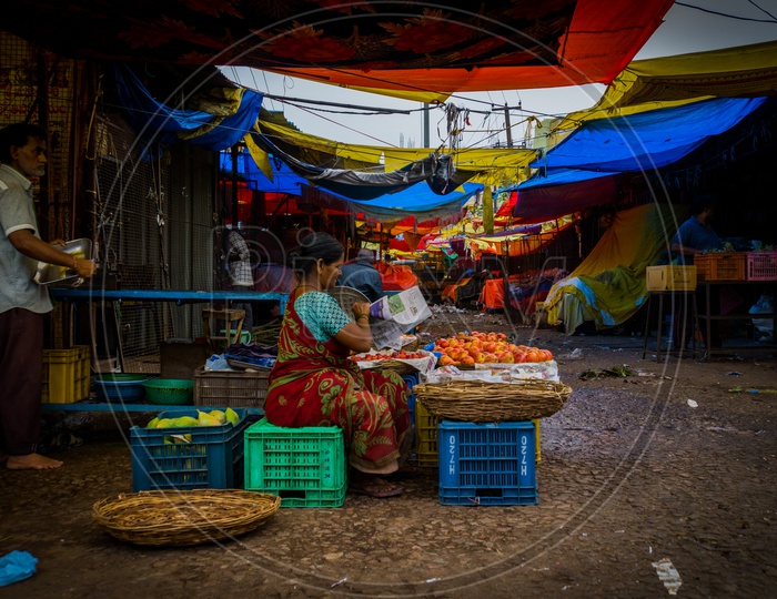 Picture of vegetable vendor setting up her stall in a vegetable market.