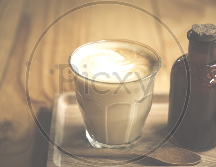 Coffee Latte Art in Coffee Cup With Sugar Bottle On an Wooden  Table Background