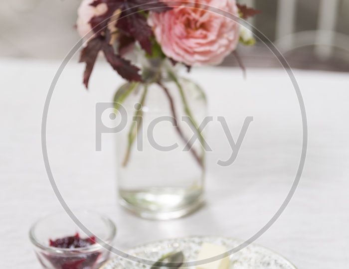 Cake In a Plate On Table With Flower Vase