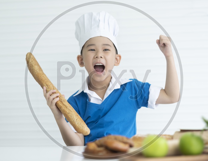 A boy as chef enjoying cooking with bread in hand