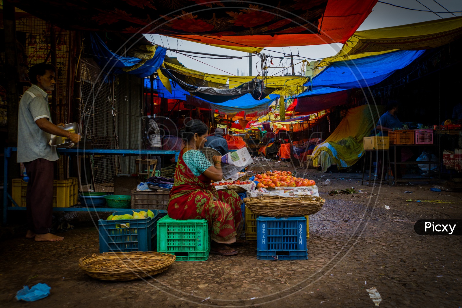 Picture of vegetable vendor setting up her stall in a vegetable market.