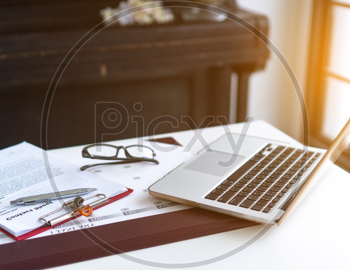 Business laptop, glasses, business schedule on the table