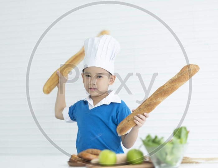 A boy as chef enjoying cooking with breads in hand
