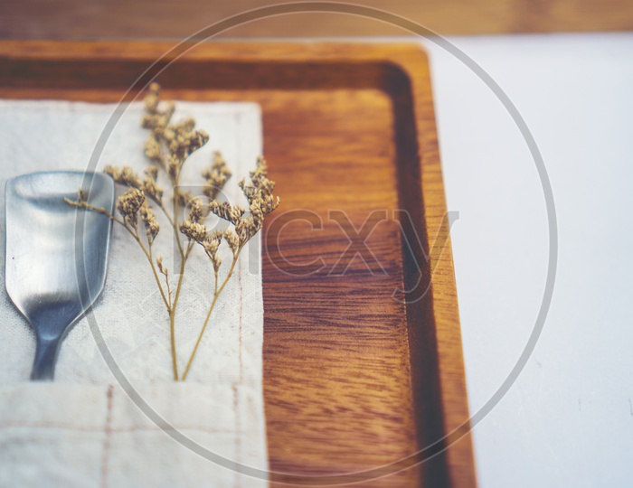 Dry flowers on the wooden tray of coffee cafe interior, vintage filter image
