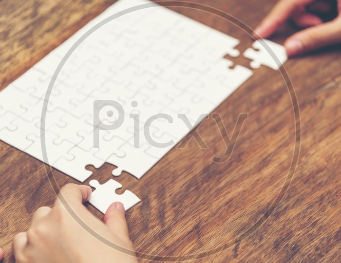 Startup Company Entrepreneur or Businessman hand connecting jigsaw puzzle.