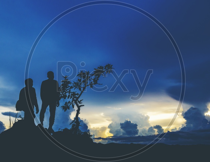 Silhouette Of Trekkers Or Climbers On a Hill Top With Blue Hour Sky Background