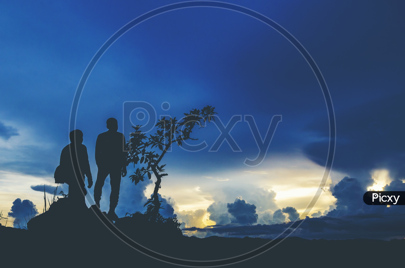 Silhouette Of Trekkers Or Climbers On a Hill Top With Blue Hour Sky Background