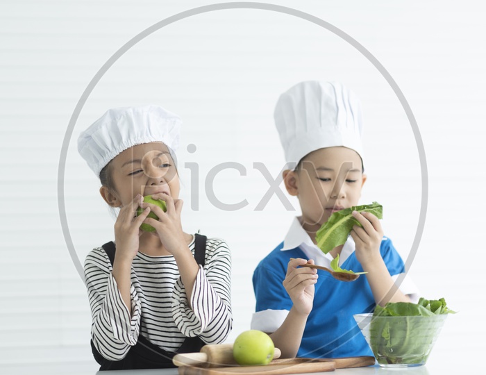 Boys as chefs enjoying cooking with vegetables  in hand