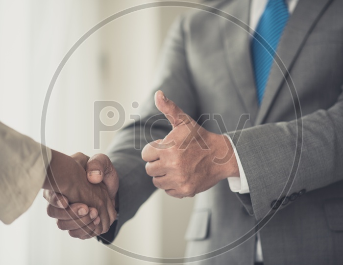 Two Young Business Man Shaking Hands with thump Up gesture Hands Closeup