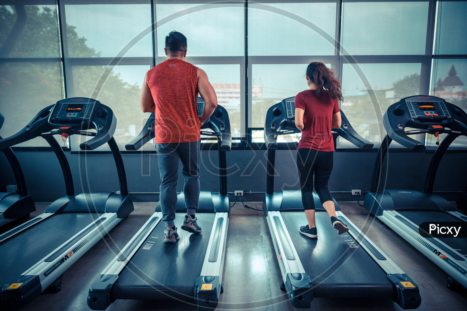 Couple on treadmill exercising in the gym